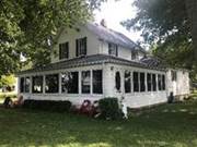 A white house with a lawn and trees

AI-generated content may be incorrect.